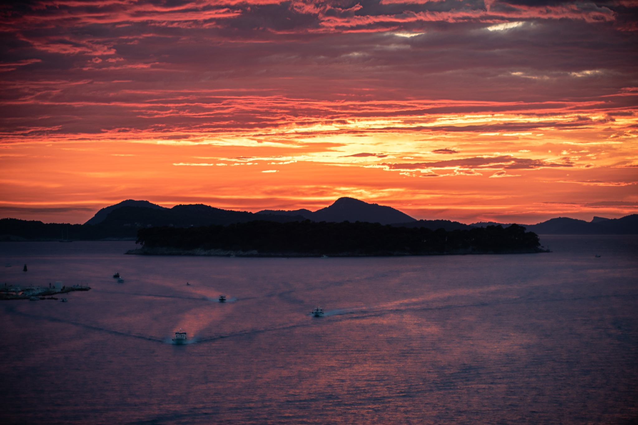 Island and sea beneath a dramatic sunset